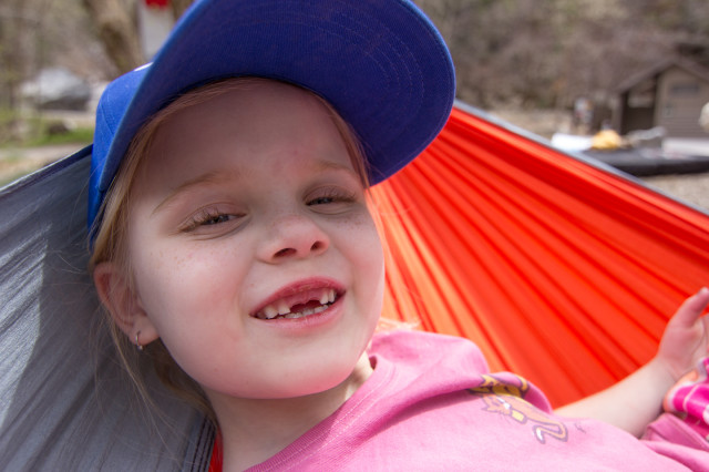 Little girl camping in hammock