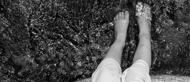 feet and toes dipped in creek